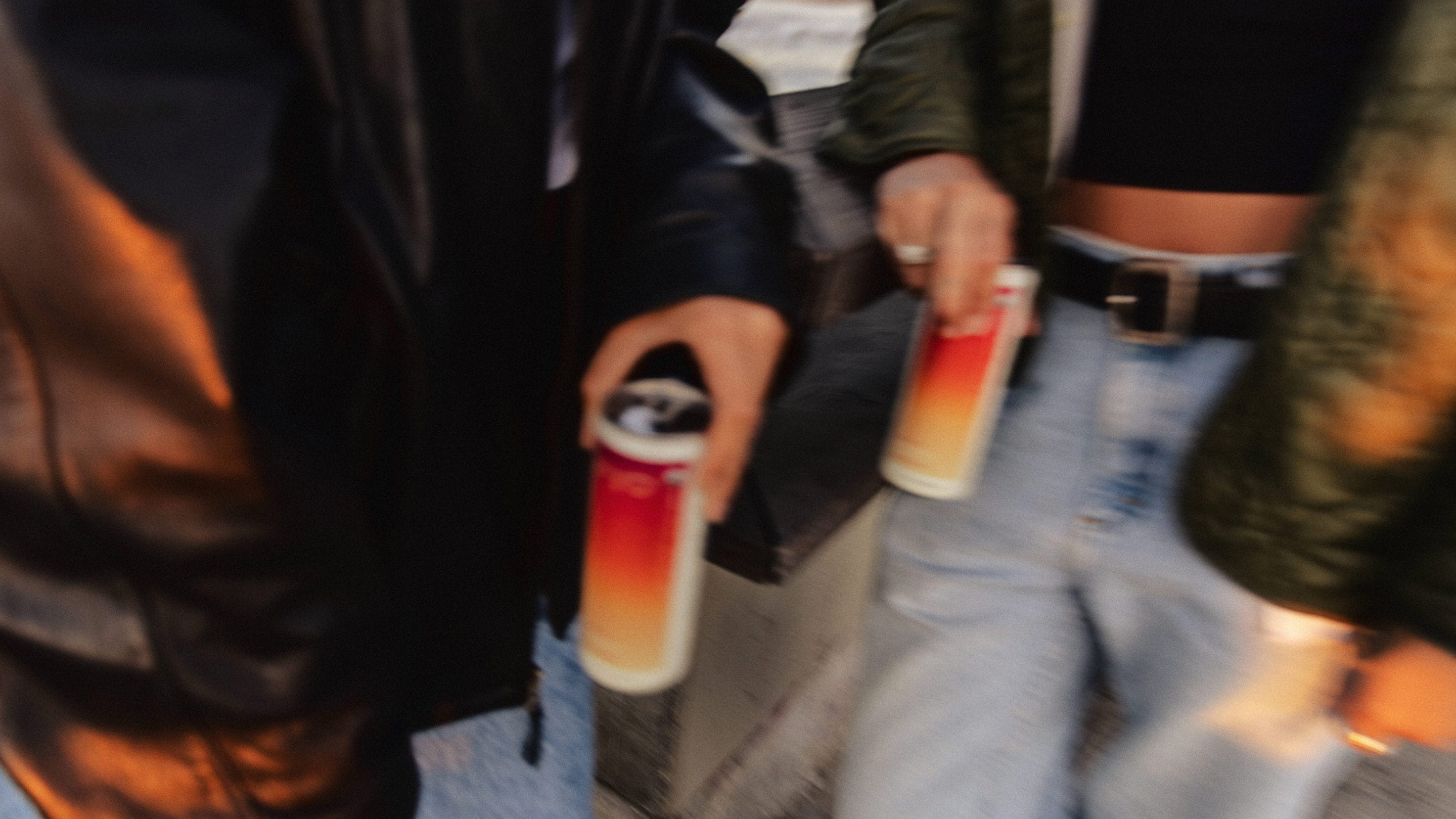 two women holding cans of strawberry hiyo casually on a boardwalk.