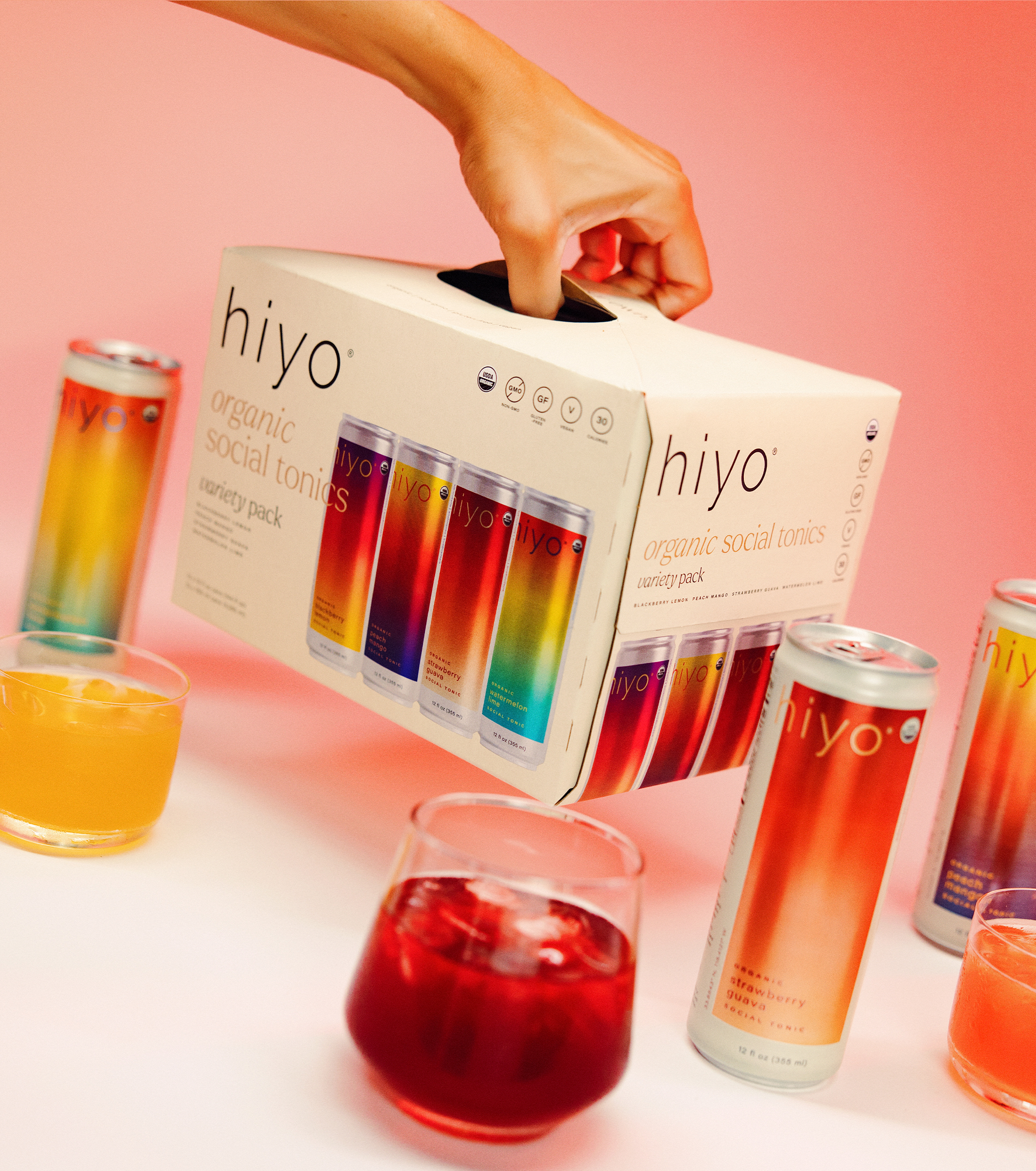 hiyo organic social tonic packaging with colorful cans and glasses on a pink background