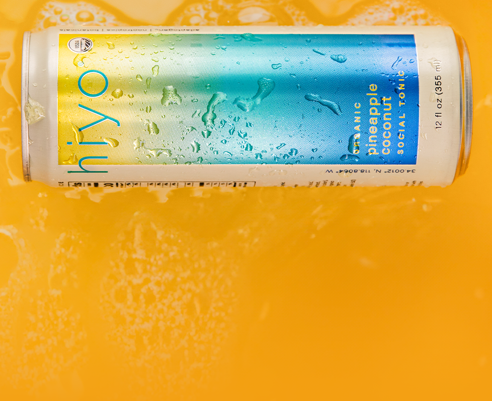 Can of non-alcoholic hiyo pineapple coconut social tonic on a yellow background